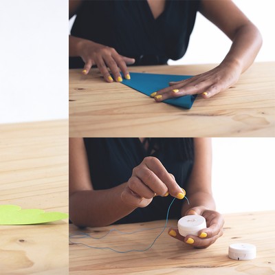 a collage of three images in which a woman is cutting pink and green cardstock into shapes, folding a piece of blue paper, and threading a hole in a white plastic cap