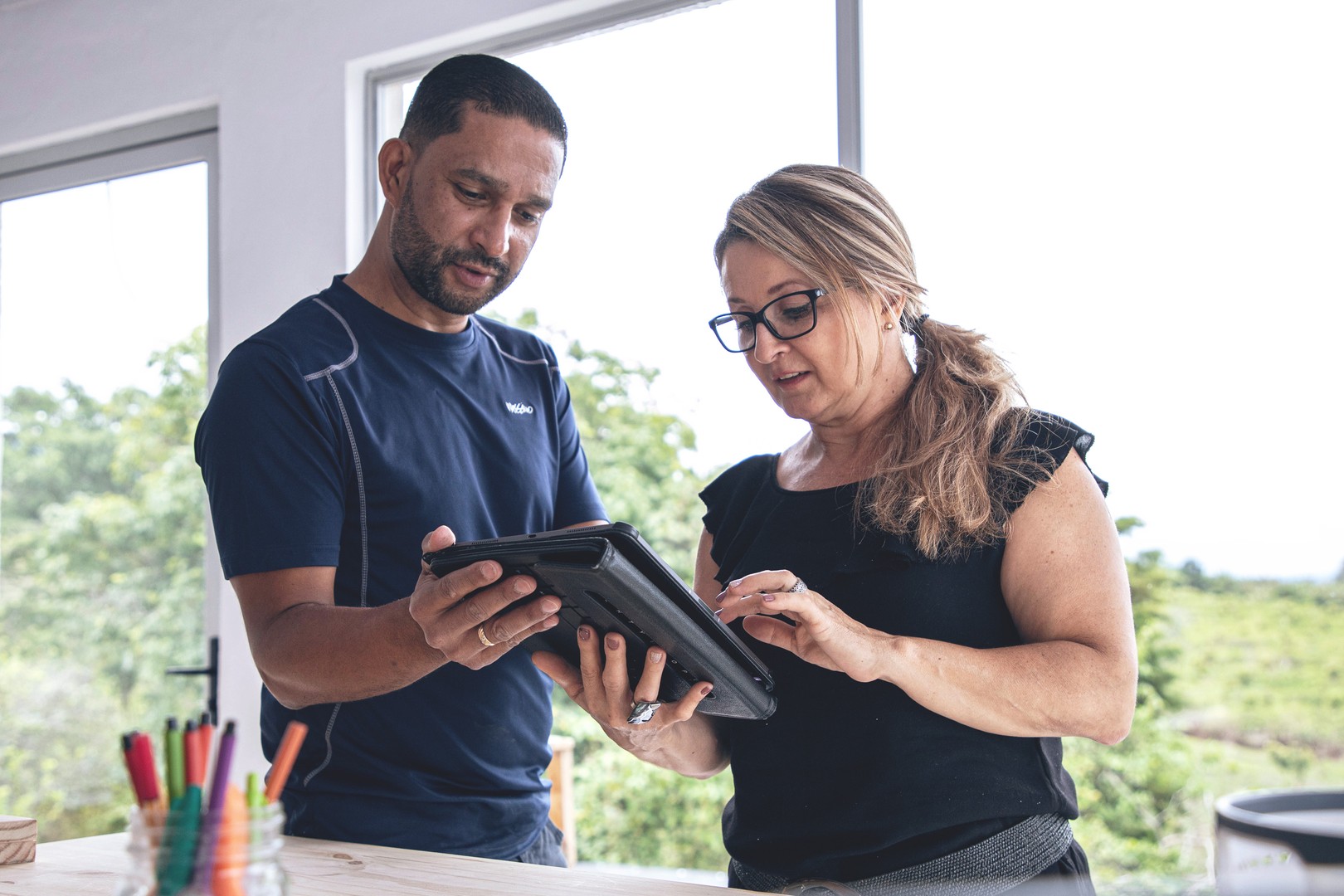 a man and a woman collaborate while viewing content on a tablet