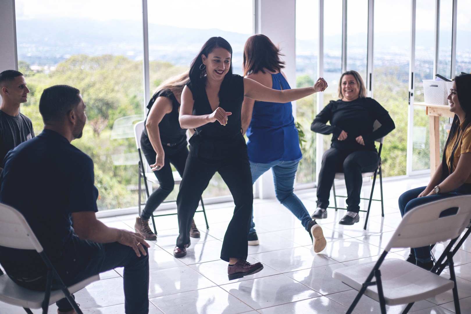 two women play a kinesthetic icebreaker with their team