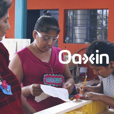 during a creative capacity building event, two women measure a piece of wood while two other women observe