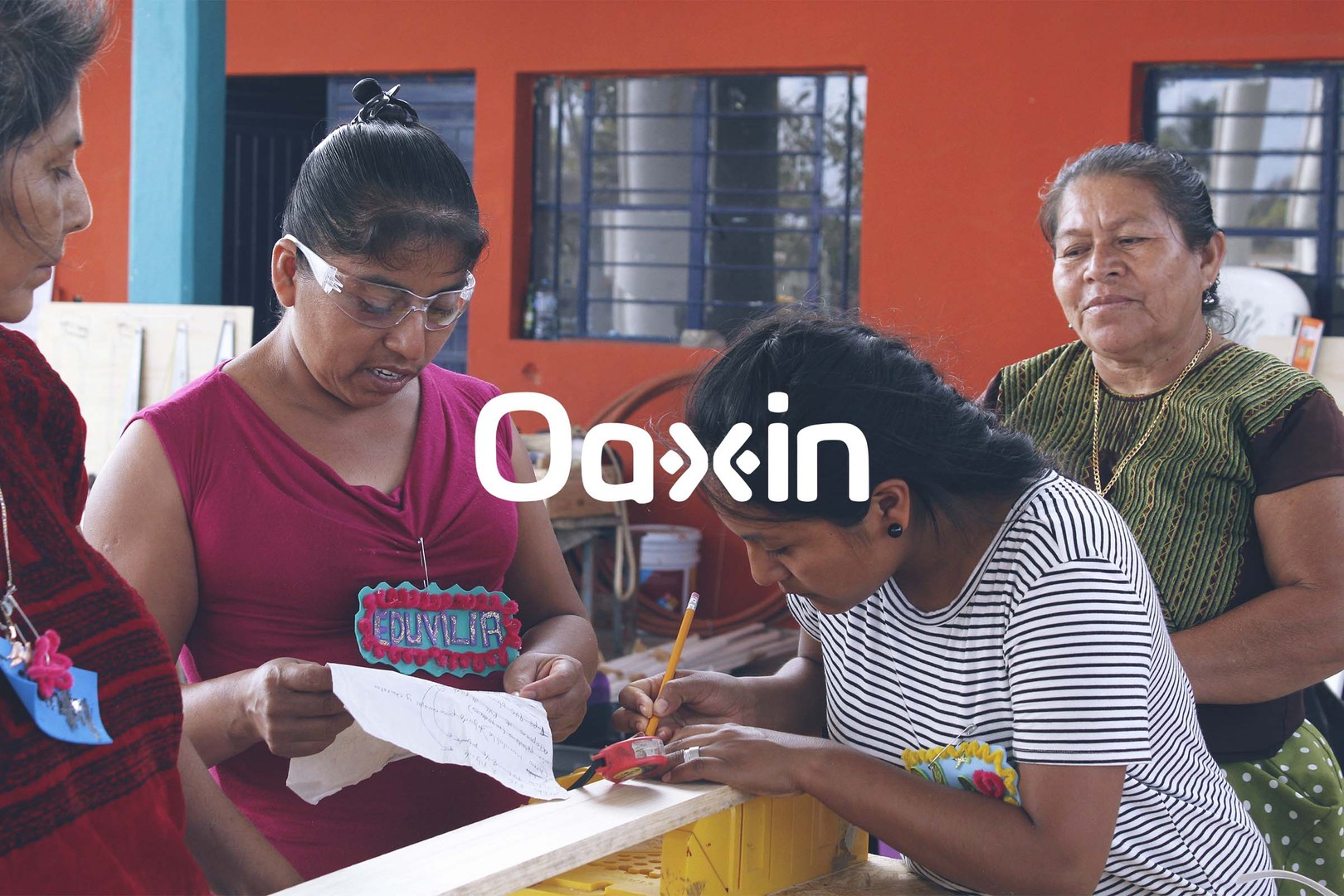 during a creative capacity building event, two women measure a piece of wood while two other women observe