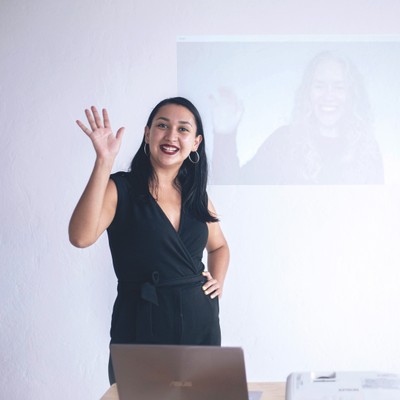 ta corrales and liz hunt (whose image is projected on the wall behind ta) wave during one of Smith Assembly’s workshops