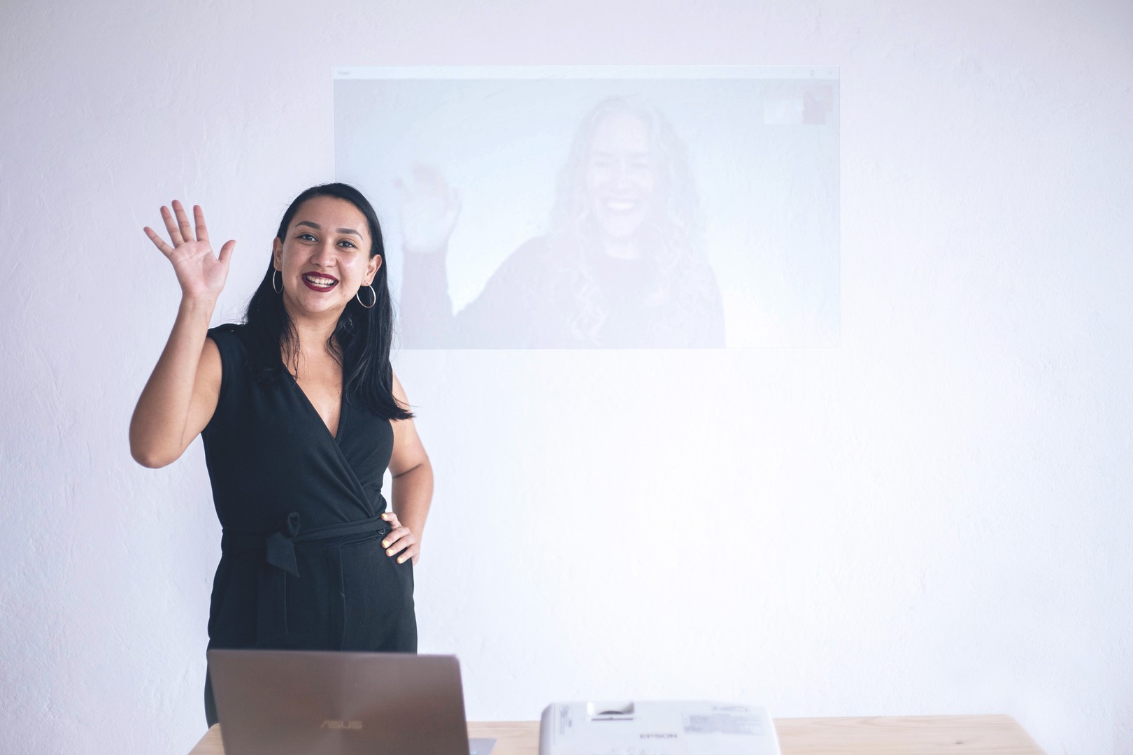 ta corrales and liz hunt (whose image is projected on the wall behind ta) wave during one of Smith Assembly’s workshops