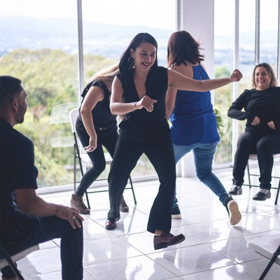 two women play a kinesthetic icebreaker with their team at the beginning of a smith assembly onsite workshop